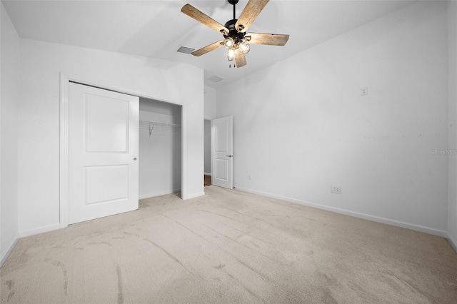 unfurnished bedroom with ceiling fan, a closet, light carpet, and vaulted ceiling