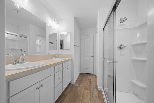 bathroom with vanity, hardwood / wood-style flooring, and a shower with shower door