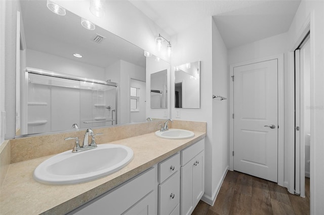 bathroom featuring wood-type flooring, vanity, and walk in shower