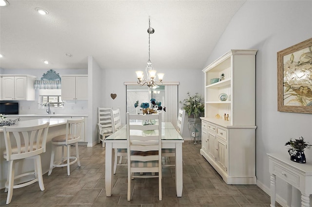 dining room featuring vaulted ceiling, sink, and an inviting chandelier