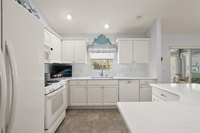 kitchen with white cabinets, white appliances, and sink