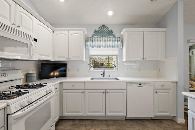 kitchen featuring white appliances, white cabinetry, and sink