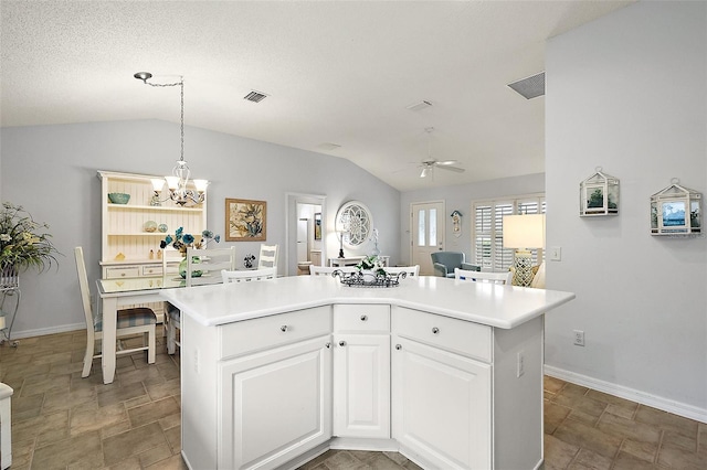 kitchen with white cabinets, ceiling fan with notable chandelier, a kitchen island, and lofted ceiling