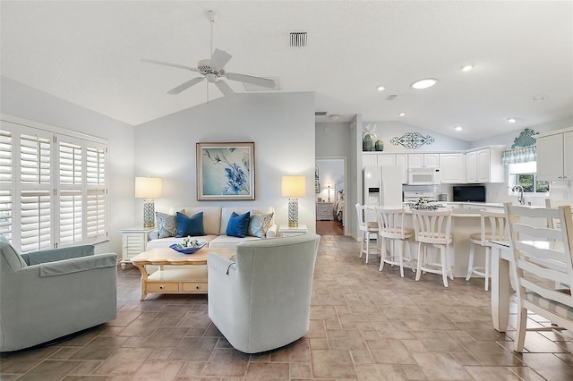 living room featuring ceiling fan, lofted ceiling, and sink