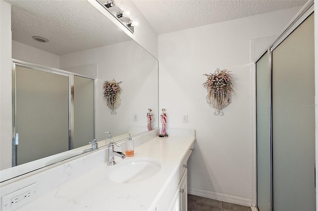 bathroom featuring a textured ceiling, tile patterned flooring, vanity, and an enclosed shower