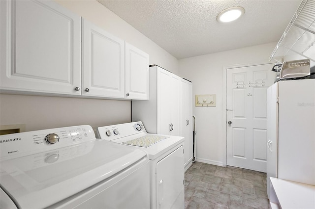 washroom with washing machine and dryer, cabinets, and a textured ceiling