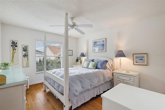 bedroom featuring ceiling fan, dark hardwood / wood-style flooring, and a textured ceiling