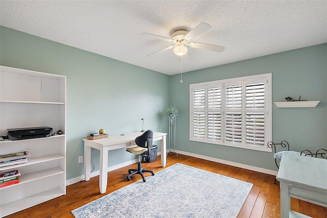 office space with ceiling fan, hardwood / wood-style floors, and a textured ceiling