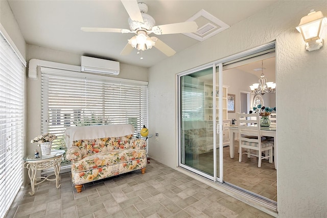 living area featuring a wealth of natural light, ceiling fan with notable chandelier, and a wall unit AC