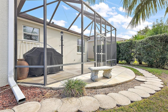 view of patio with grilling area and a lanai