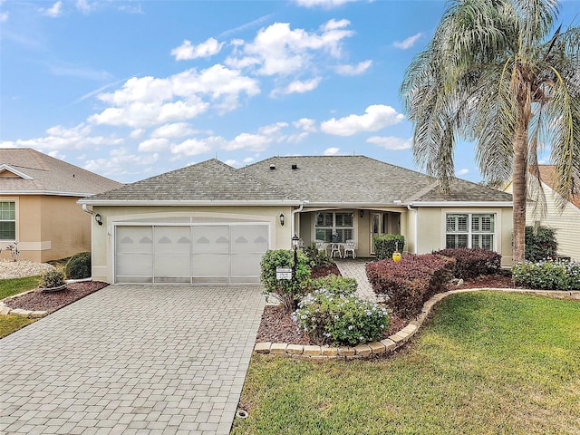 single story home with a porch, a garage, and a front lawn