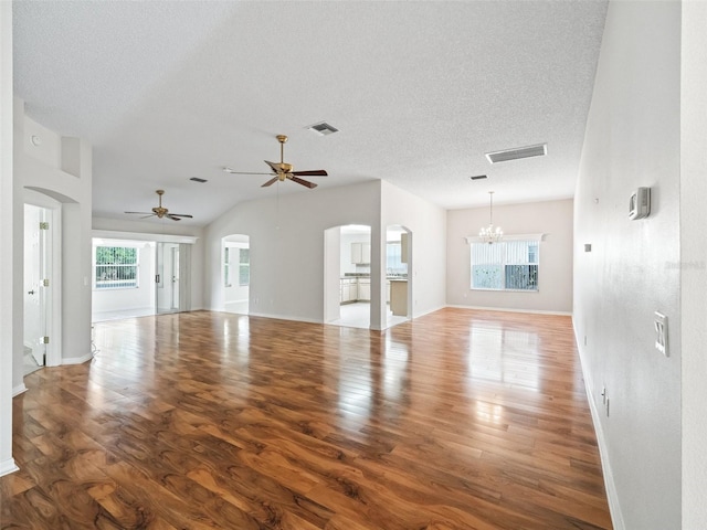 unfurnished living room featuring a textured ceiling, hardwood / wood-style floors, a healthy amount of sunlight, and ceiling fan with notable chandelier