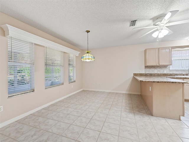 interior space featuring ceiling fan, light tile patterned floors, and a textured ceiling