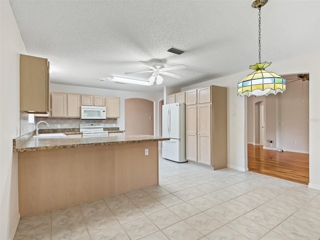 kitchen featuring decorative backsplash, kitchen peninsula, white appliances, sink, and hanging light fixtures