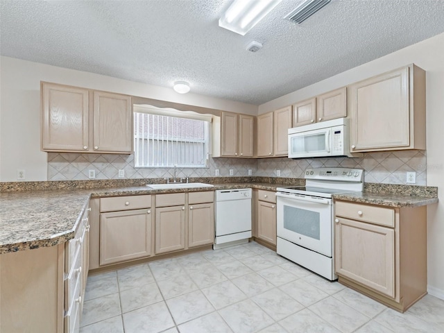 kitchen featuring a textured ceiling, light brown cabinetry, sink, and white appliances