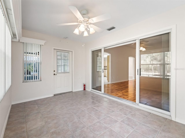 tiled spare room featuring ceiling fan