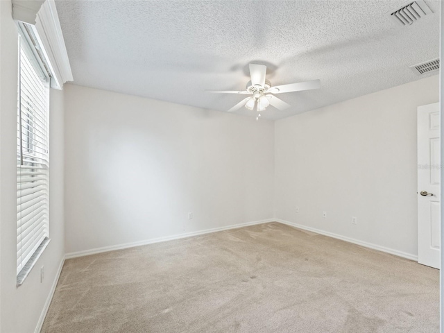 carpeted empty room with a textured ceiling and ceiling fan