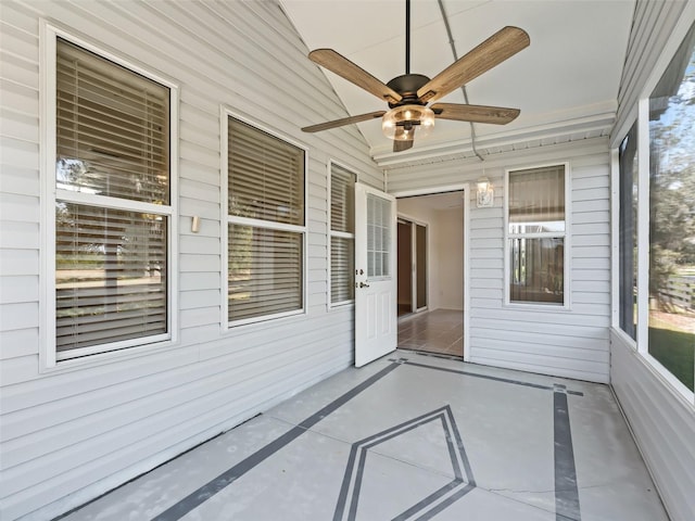 unfurnished sunroom with ceiling fan