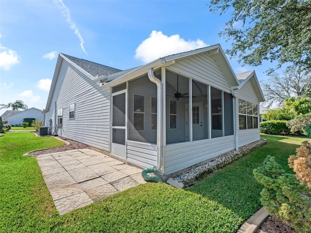 view of property exterior featuring a sunroom, a patio area, a lawn, and central AC