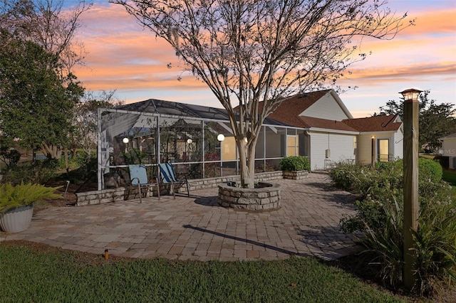 patio terrace at dusk featuring a lanai