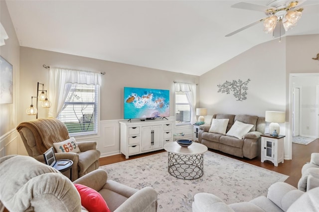 living room featuring a wainscoted wall, vaulted ceiling, a decorative wall, and wood finished floors