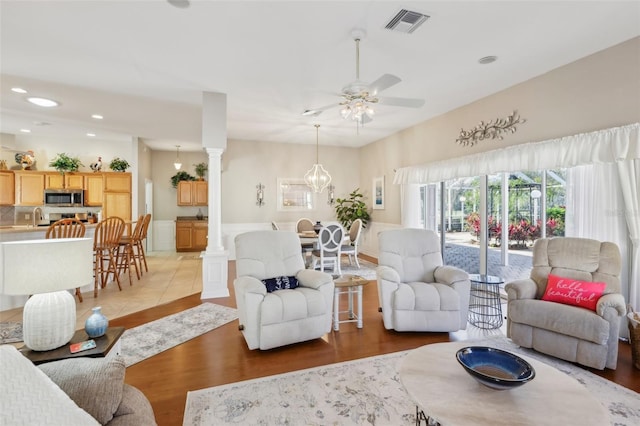 living room featuring ornate columns, ceiling fan, dark hardwood / wood-style flooring, and sink