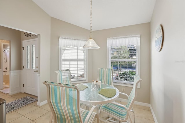 tiled dining room featuring lofted ceiling