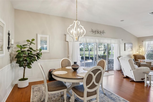 dining room featuring dark hardwood / wood-style flooring, vaulted ceiling, and a notable chandelier