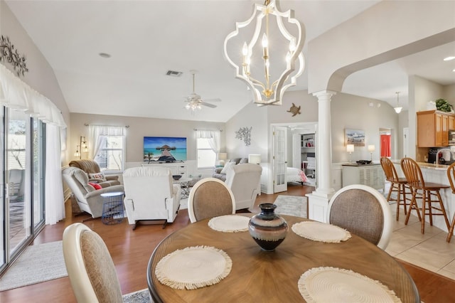 dining area featuring tile patterned flooring, lofted ceiling, ornate columns, and ceiling fan with notable chandelier