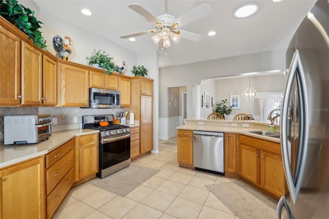 kitchen featuring appliances with stainless steel finishes, ceiling fan with notable chandelier, sink, decorative light fixtures, and light tile patterned flooring