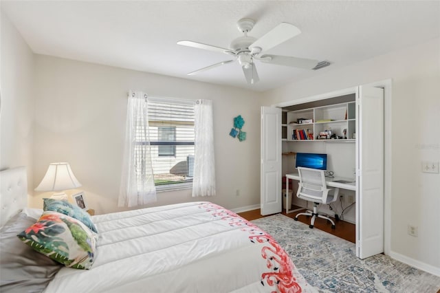 bedroom with baseboards, visible vents, ceiling fan, and wood finished floors