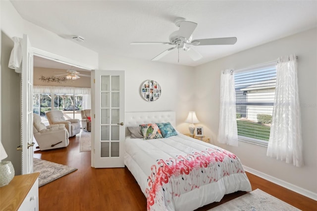 bedroom with ceiling fan, baseboards, and wood finished floors