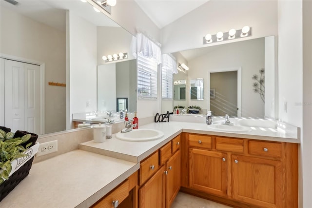 full bathroom with double vanity, visible vents, vaulted ceiling, and a sink