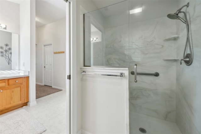 full bathroom with a marble finish shower, vanity, and baseboards