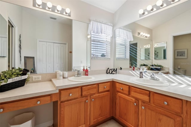 full bathroom with double vanity, a sink, and visible vents