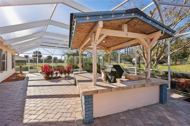 view of patio with a gazebo, a lanai, and a grill