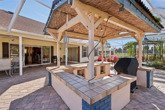 view of patio / terrace with a lanai and a grill