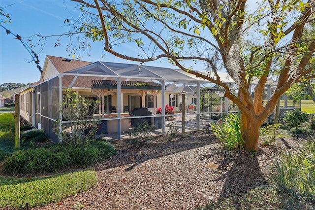 rear view of property featuring a swimming pool, a patio area, and a lanai