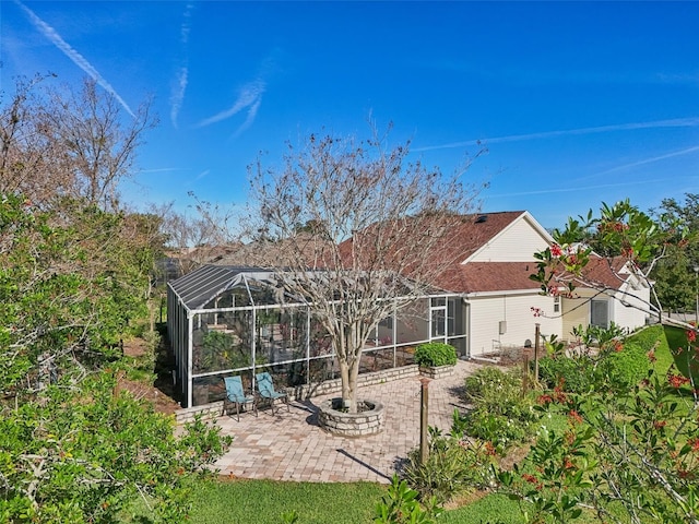 back of house featuring glass enclosure and a patio