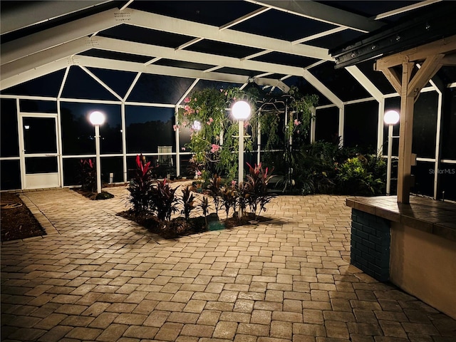 patio at night featuring glass enclosure