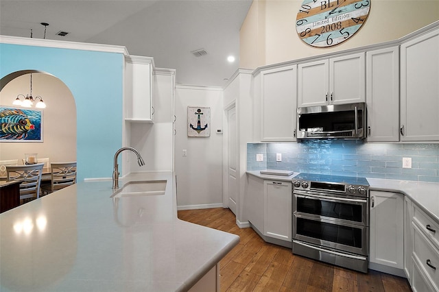 kitchen with an inviting chandelier, sink, appliances with stainless steel finishes, tasteful backsplash, and white cabinetry