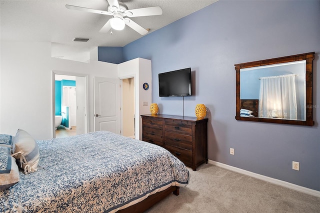 bedroom with lofted ceiling, light carpet, ceiling fan, a textured ceiling, and connected bathroom