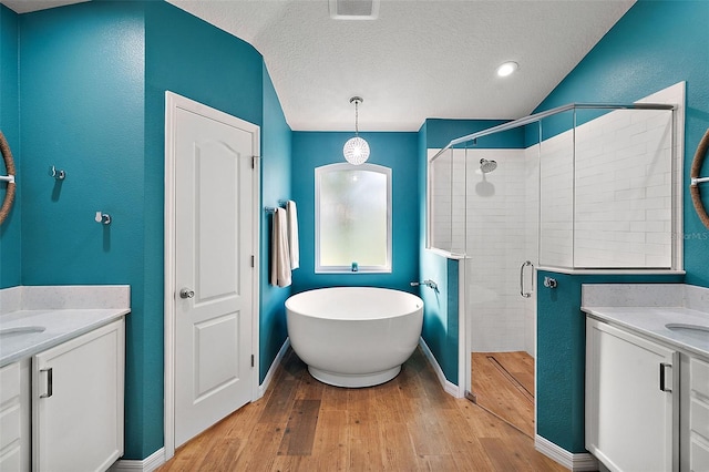 bathroom featuring vanity, a textured ceiling, separate shower and tub, hardwood / wood-style floors, and lofted ceiling