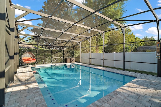 view of swimming pool with glass enclosure and a patio area