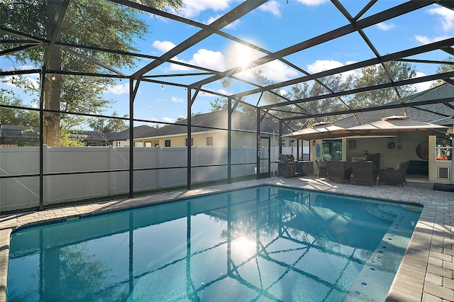 view of pool with glass enclosure, a patio area, and grilling area