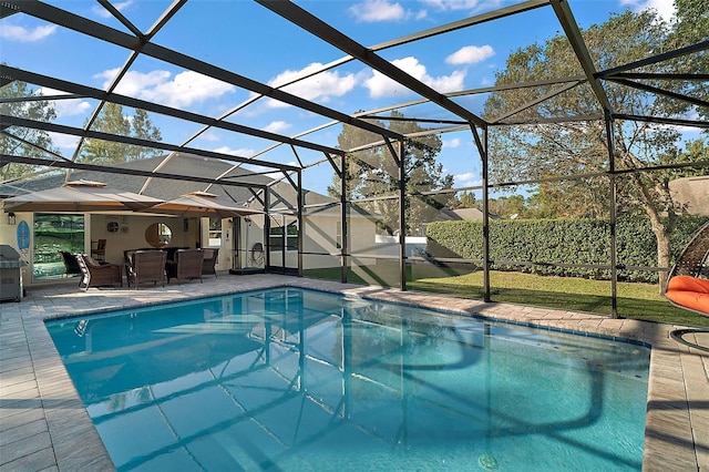 view of swimming pool featuring glass enclosure and a patio area