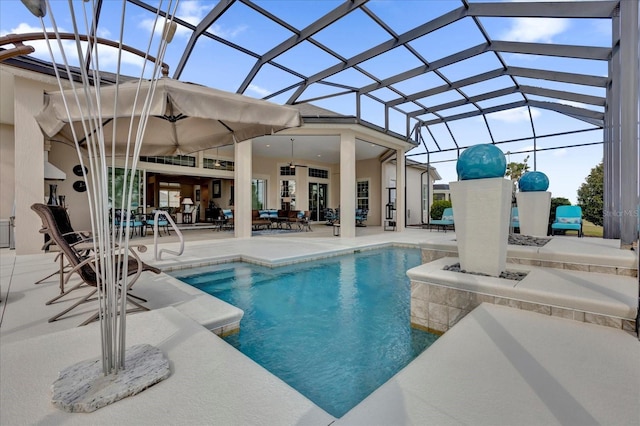 view of swimming pool featuring glass enclosure, ceiling fan, and a patio area