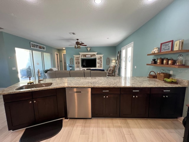 kitchen with dishwasher, dark brown cabinetry, light stone counters, and sink