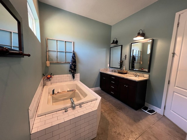 bathroom with vanity, tile patterned flooring, and a relaxing tiled tub