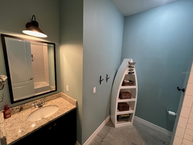 bathroom featuring tile patterned floors, vanity, and a textured ceiling